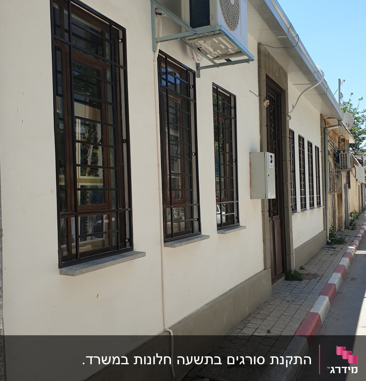 חלונות עם מסגרות מתכת על קיר חיצוני של בניין